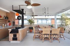 an open kitchen and dining room area with wood cabinets, tile flooring and ceiling fan