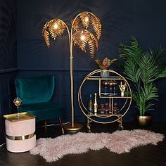 a living room filled with furniture and a gold shelf next to a green velvet chair