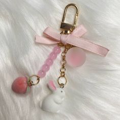 a keychain with a bunny on it and a pink bead around the neck