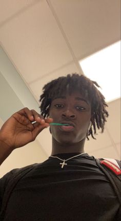 a woman brushing her teeth with a green toothbrush