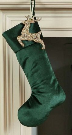 a green christmas stocking hanging from a fireplace