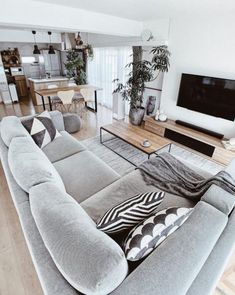 a living room filled with furniture and a large flat screen tv mounted to the wall