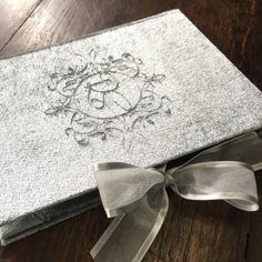 a close up of a book on a wooden floor with a ribbon around the cover