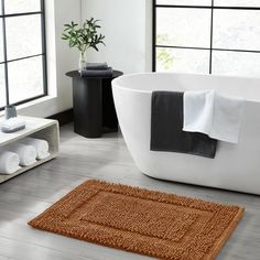 a bath tub sitting next to a window in a bathroom