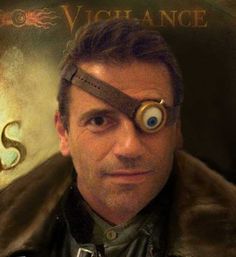 a man with googly eyes is looking at the camera and has an eyeball on his forehead