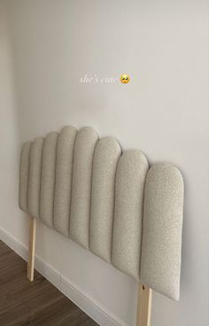 a row of chairs sitting on top of a wooden floor next to a white wall