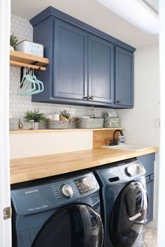 a washer and dryer in a kitchen with blue cabinets