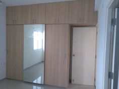 an empty room with wooden cabinets and mirrored doors