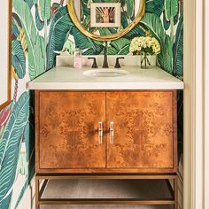 a bathroom vanity with a mirror, sink and wallpaper