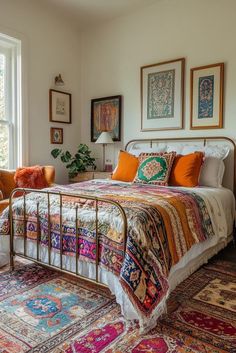 a bed sitting in a bedroom next to a window with pictures on the wall above it