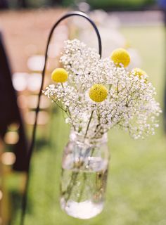 a vase filled with flowers sitting on top of a grass covered field