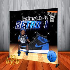 a boy sitting on top of a blue shoe next to a basketball