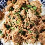 a blue and white plate topped with meat and rice