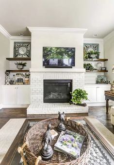 a living room filled with furniture and a fire place in front of a tv mounted on the wall