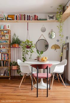 a dining room table and chairs with bookshelves in the background