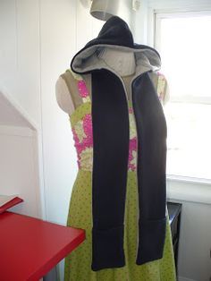 a woman's dress on display in front of a window with a red table