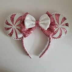 a pink and white minnie mouse ears with candy canes