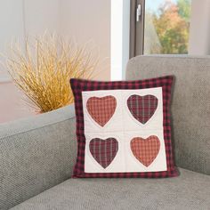 a pillow with four hearts on it sitting on a couch