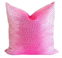 a pink pillow with white dots on it