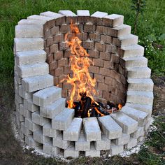 a fire pit made out of cinder blocks with flames coming out of the top and sides