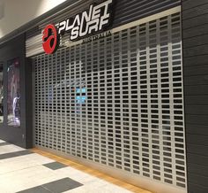 the entrance to planet surf australia in an indoor shopping area with black and white tile flooring