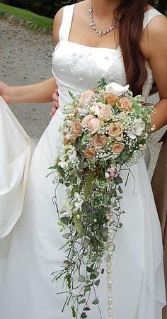 a woman in a wedding dress holding a bridal bouquet