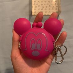 a hand holding a pink mickey mouse keychain