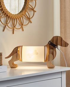 a wooden dachshund lamp sitting on top of a white dresser