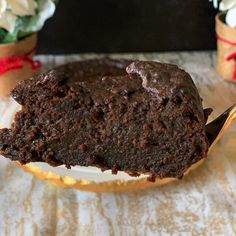 a piece of chocolate cake sitting on top of a plate with a fork in it