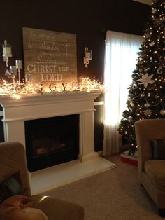 a living room decorated for christmas with lights on the mantel and decorations around the fireplace