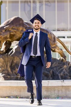 a man in a suit and tie walking past a statue