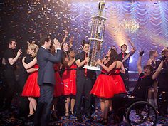 a group of people standing on top of a stage with confetti in the air