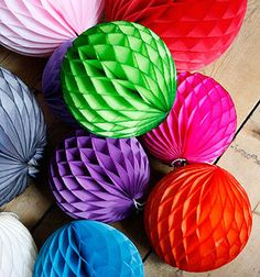 colorful paper honeycombs laid out on a wooden floor for decoration or decorating