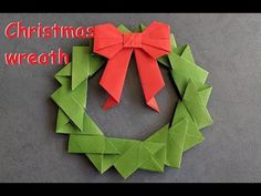 an origami wreath with a red bow on it and the words christmas wreath