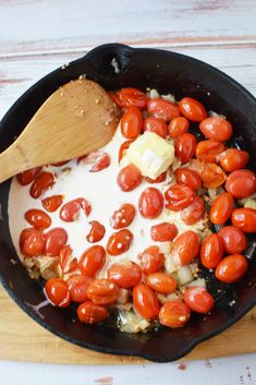 tomatoes being cooked in a skillet with cream