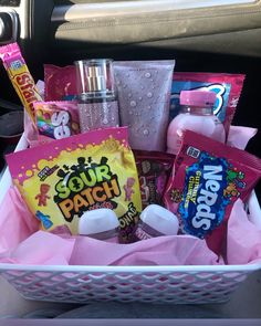 a basket filled with candy and snacks in the back seat of a car or truck