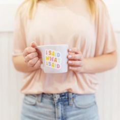 a woman holding a coffee mug with the words i am what i said on it