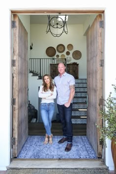 a man and woman standing in an open doorway