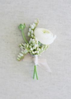 the boutonniere is adorned with white flowers and baby's breath buds