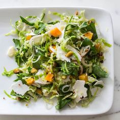 a white plate topped with salad on top of a table