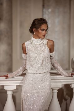 a woman in a white dress leaning on a railing