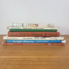 a stack of books sitting on top of a wooden table