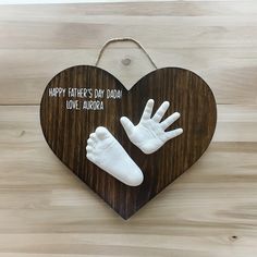 a wooden heart shaped sign with two hands and the words happy father's day mom love aurora