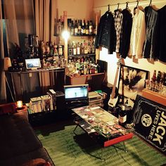 a living room filled with lots of furniture and shelves full of bottles, books, and other items