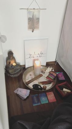 a table topped with lots of items on top of a wooden floor next to a white wall