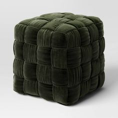 a green square foot stool made out of velvet material with an interlocked design