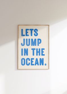 a blue and white poster with the words lets jump in the ocean written below it