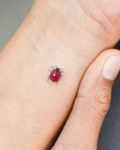 a ladybug tattoo on the left wrist