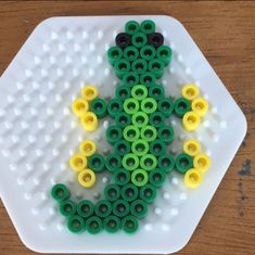 a white plate topped with green and yellow beads