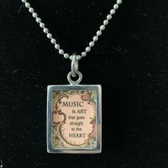 a necklace with a quote on it that reads music is art that goes straight to the heart